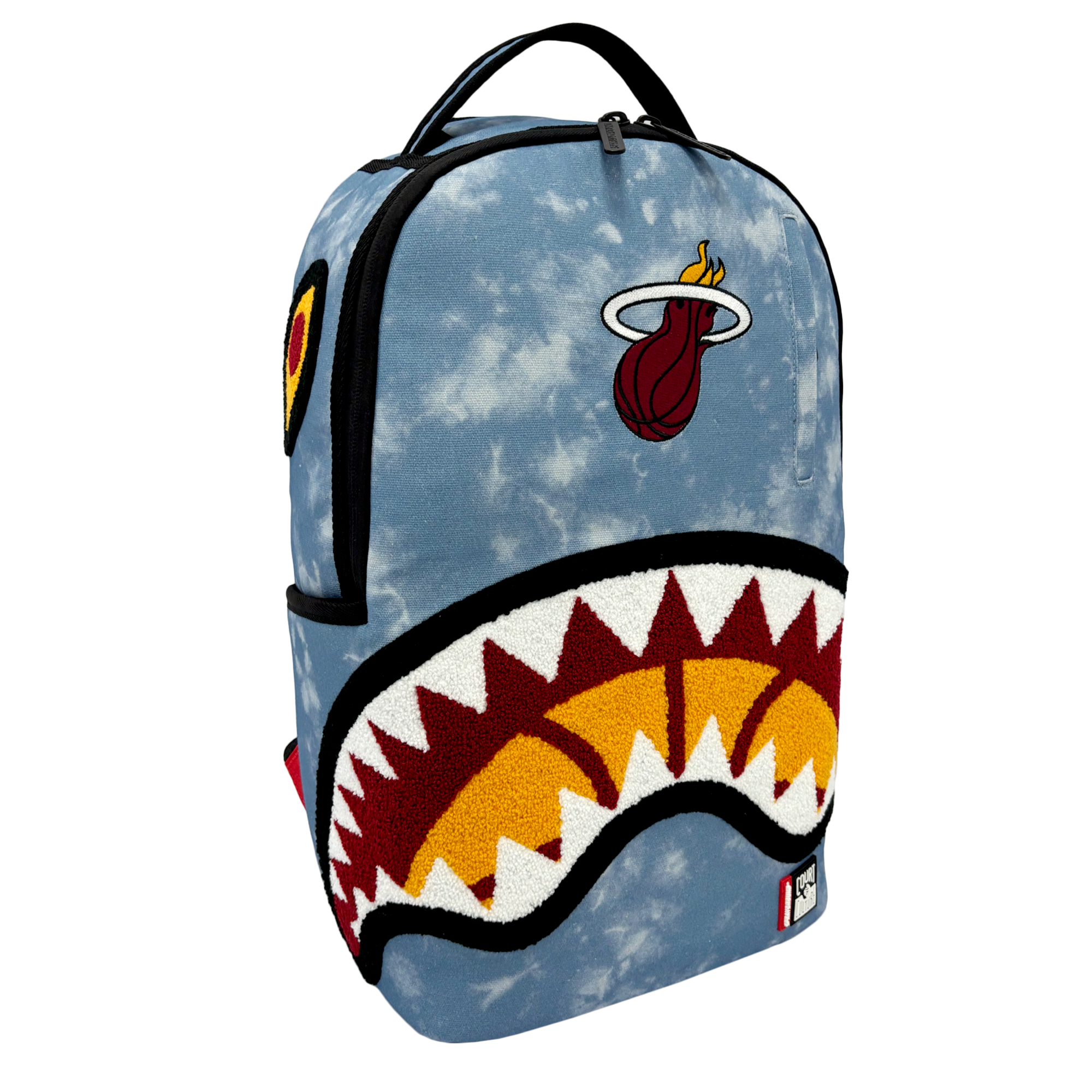 Introducing the Court Culture x Sprayground Miami HEAT Tie-Dye Jaw Backpack by Sprayground. This limited edition denim backpack showcases a striking tie-dye, cloud-inspired pattern, a bold shark mouth graphic on the front, and an embroidered Miami HEAT logo above. Small patch details accent the side and bottom, making this standout piece perfect for fans and collectors alike.