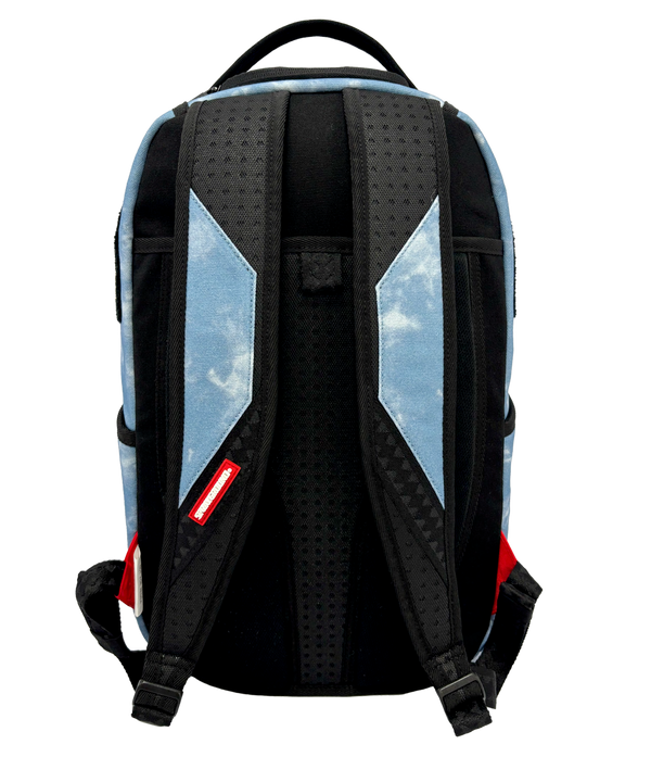 Introducing the Court Culture x Sprayground Miami HEAT Tie-Dye Jaw Backpack by Sprayground—a limited edition piece crafted from blue denim and showcasing an embroidered Miami Heat logo at the top, along with a bold shark mouth design over an orange basketball graphic on the front.