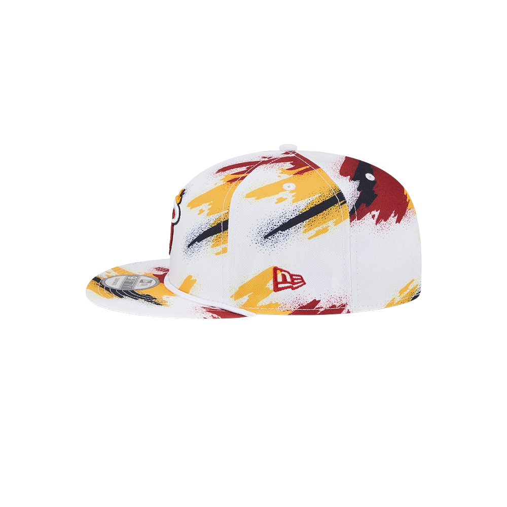 The New Era Miami HEAT Youth Paint Snapback is a white, flat-brim polyester cap with red, yellow, and black brushstroke patterns and a small red New Era logo. One size fits most; spot clean for best care.