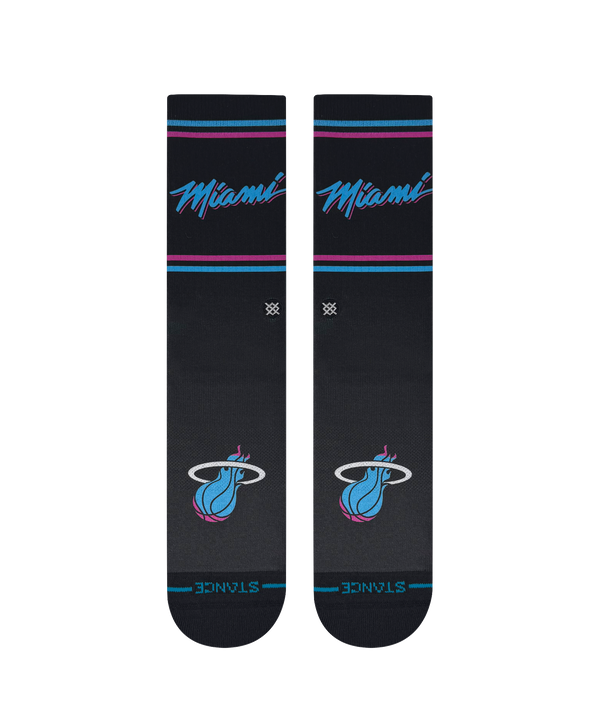 The Stance Miami HEAT Original Vice Nights Socks feature teal and pink stripes, a flaming basketball logo, and “Finals” near the toes. These dark gray crew socks have a ribbed texture and mid cushion, shown upright against a plain background.