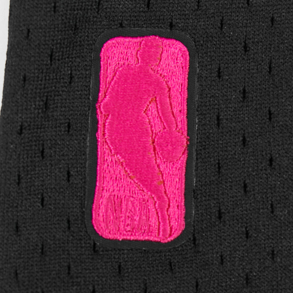 A close-up of the Pro Standard Miami HEAT Original Vice Nights Youth Mesh Shirt by Pro Standard shows black polyester fabric with a pink stitched NBA logo and basketball player silhouette; standard fit, machine washable.