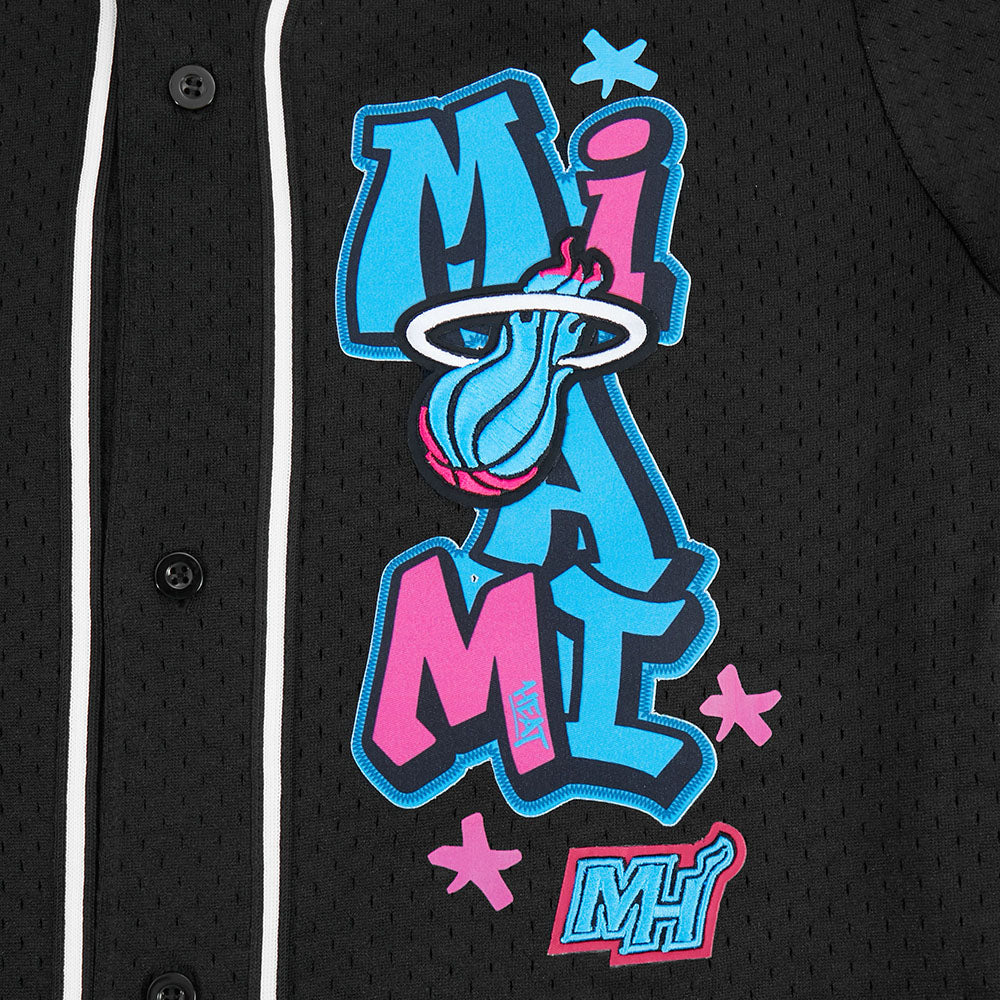 Close-up of the Pro Standard Miami HEAT Original Vice Nights Youth Mesh Shirt, a black polyester jersey with graffiti-style blue and pink MIAMI text (basketball for the “I”), standard fit, Miami Heat logo at bottom; machine washable.