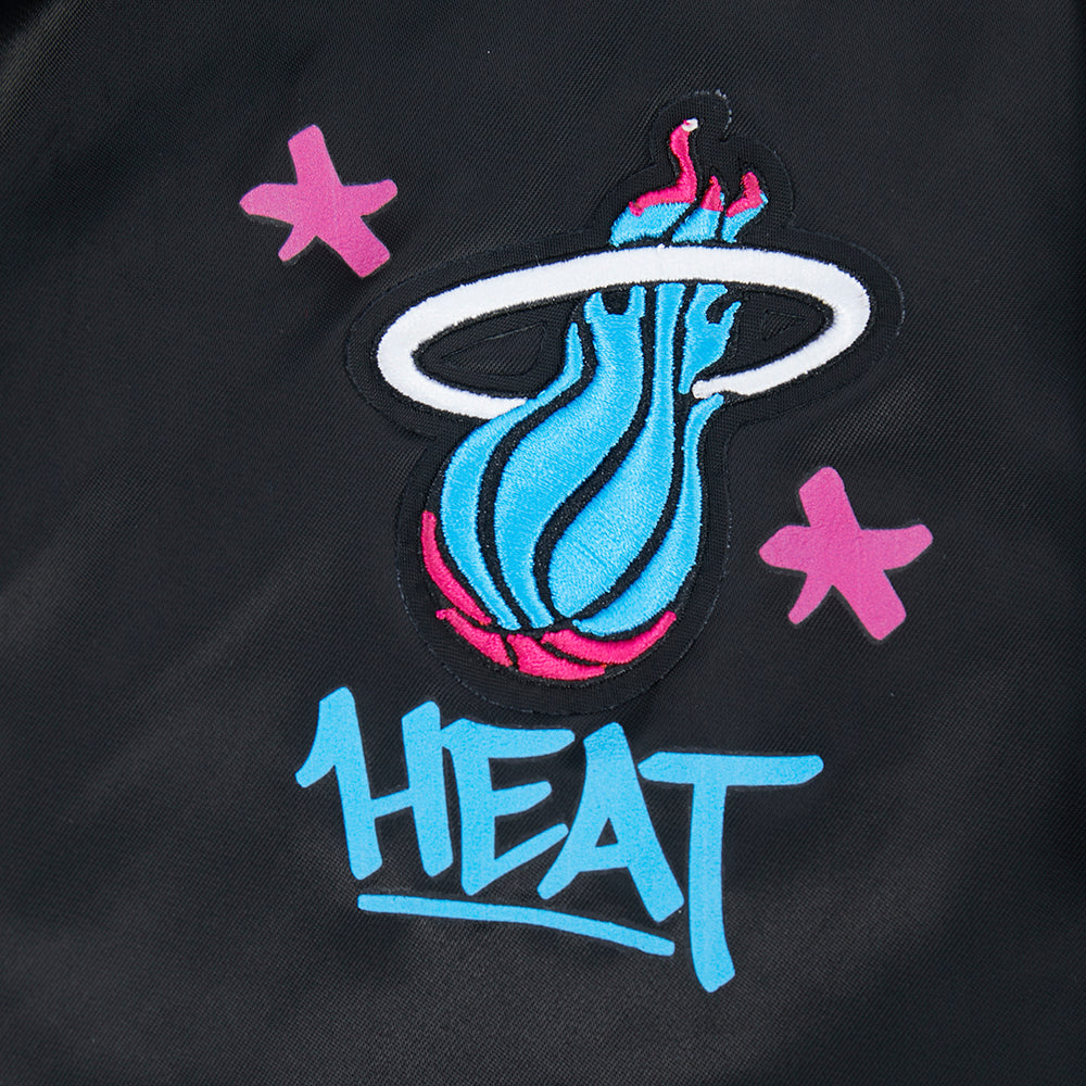 The Pro Standard Miami HEAT Original Vice Nights Youth Satin Jacket features a blue flaming basketball logo and graffiti-style HEAT lettering on black satin. Standard fit, machine washable, and made by Pro Standard for easy care.