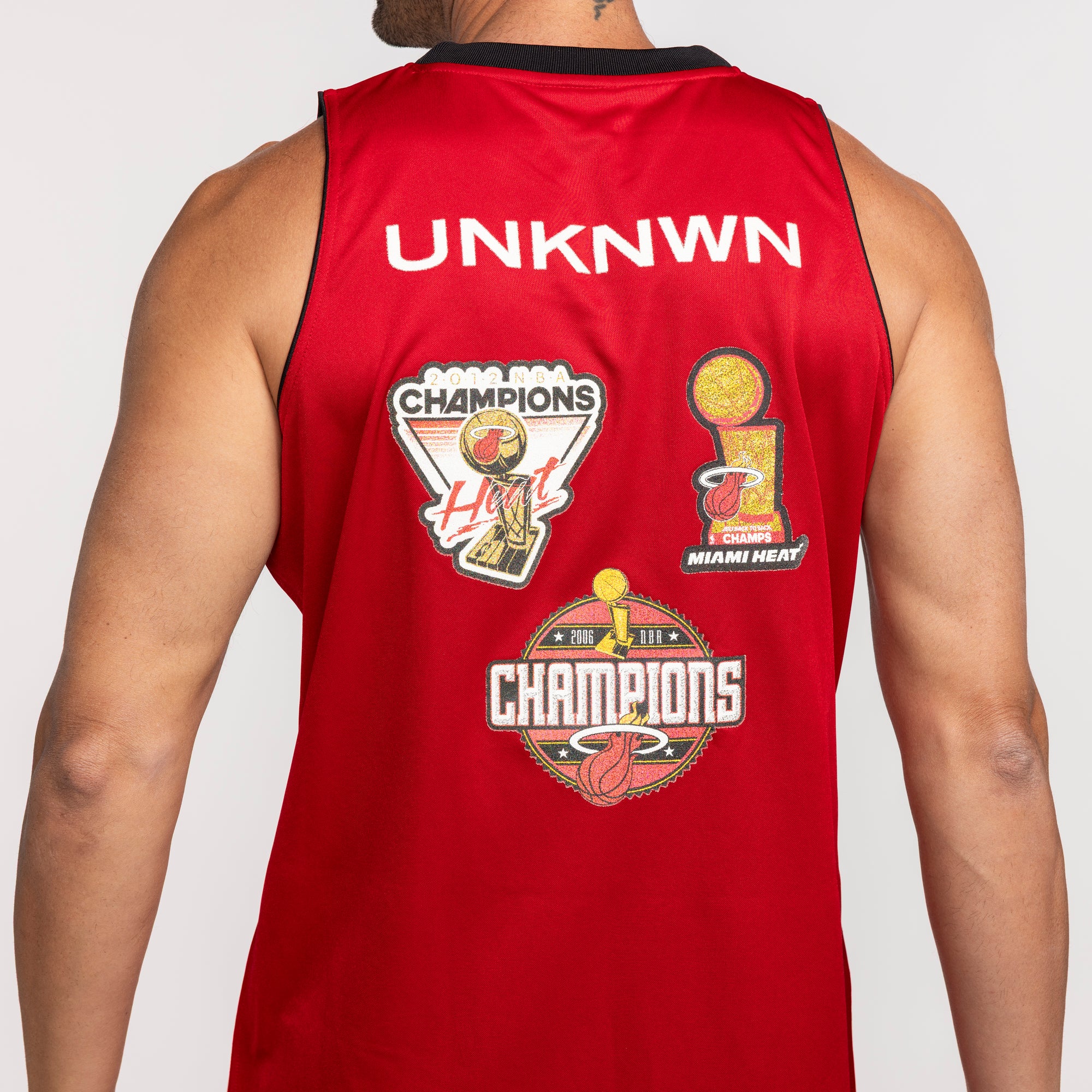 Red Miami HEAT jersey with black collar, UNKNWN text, and multiple championship patches on back. - UNKNWN X Mitchell and Ness X Miami HEAT My Towns Fashion Jersey