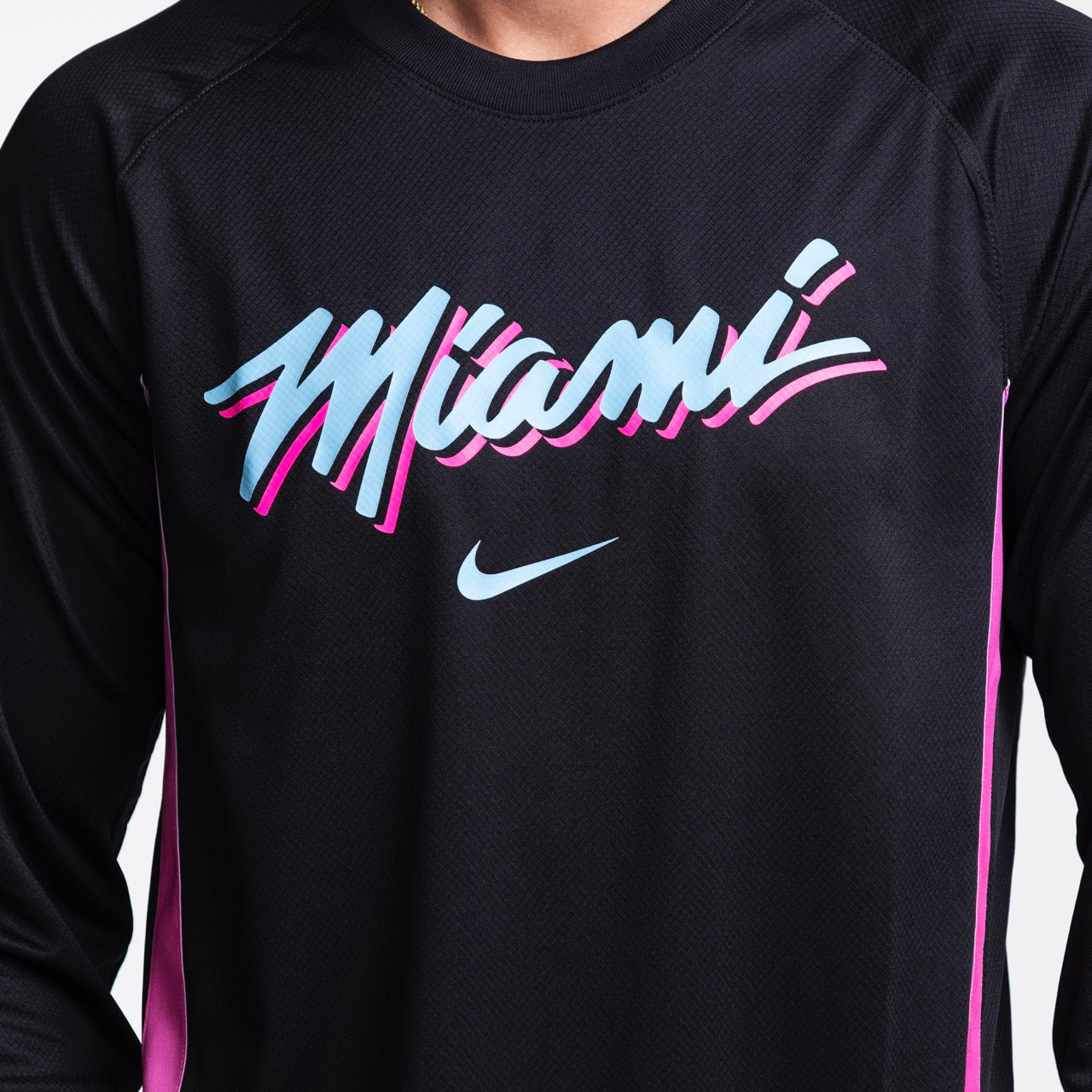 A person wears the Nike Miami HEAT Original Vice Nights Shooting Shirt, a black polyester jersey with 