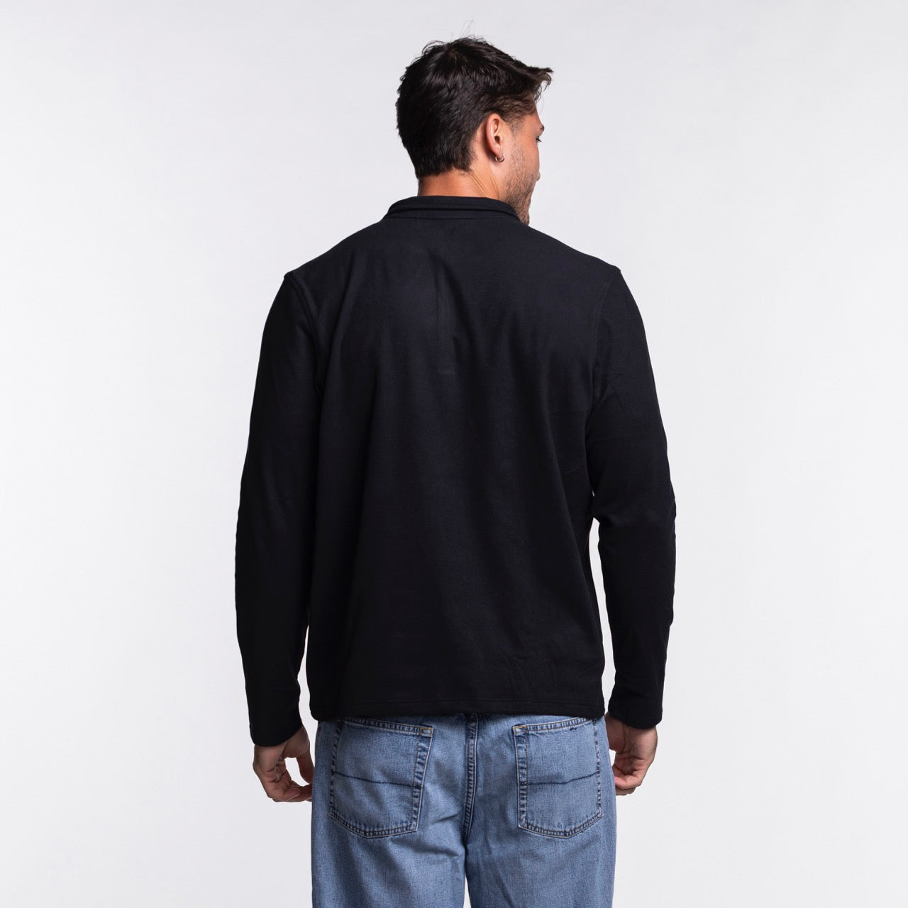 A man with short brown hair stands with his back to the camera, wearing an Antigua Miami HEAT Original Vice Nights 1/4 Zip Jacket and blue jeans against a plain white background.