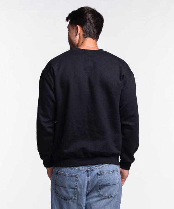 A man smiles in an Item Of The Game Miami HEAT NBA Basketball Crewneck, crafted from soft cotton-polyester, paired with blue jeans against a plain white background.