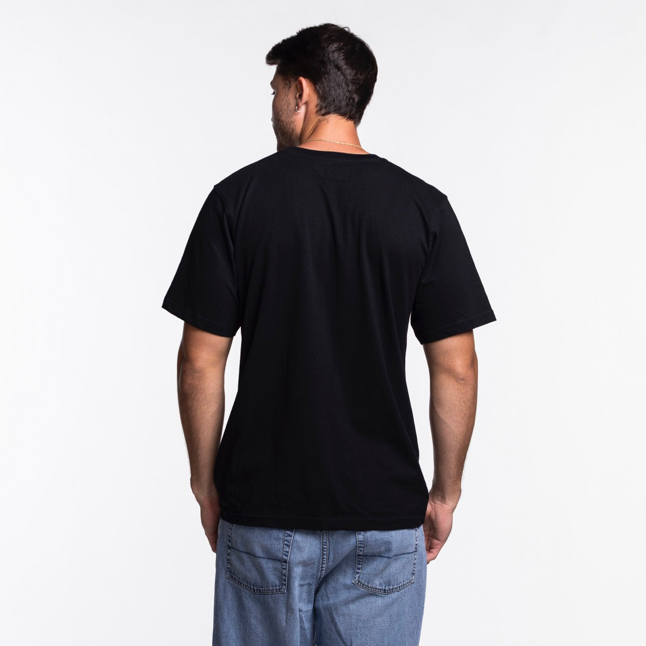 A man stands with his back to the camera, wearing a Sportiqe Miami HEAT Original Vice Nights Star Tee and light blue jeans against a white background.