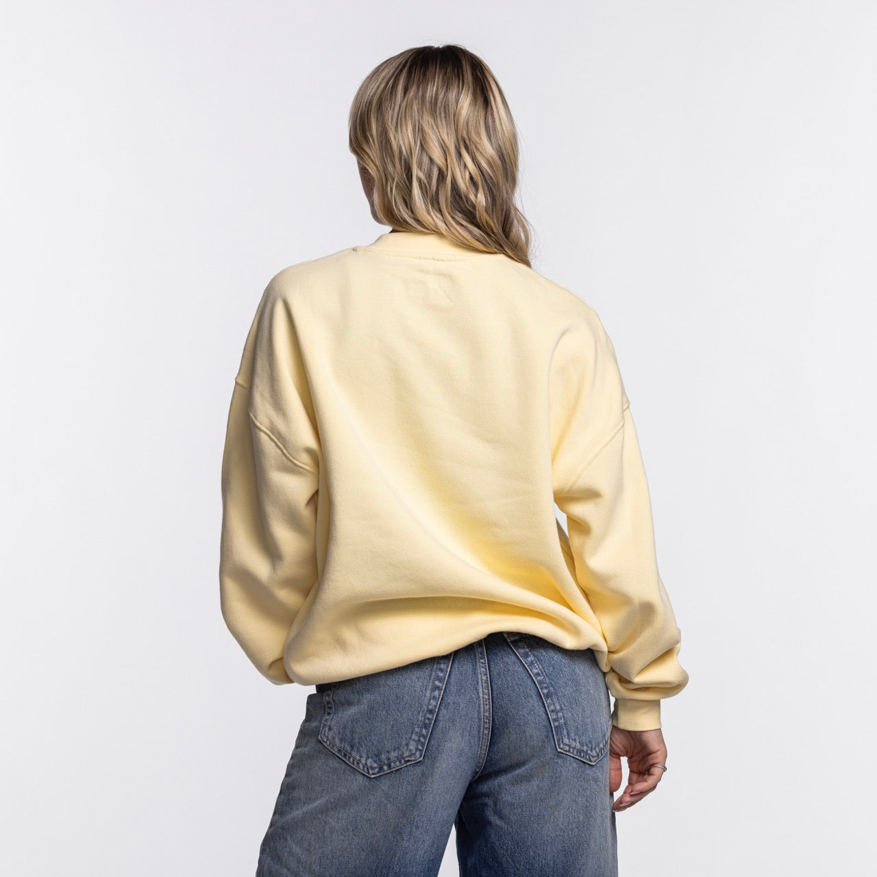 A person with blonde hair, in an oversized light yellow Court Culture Original Vice Nights 