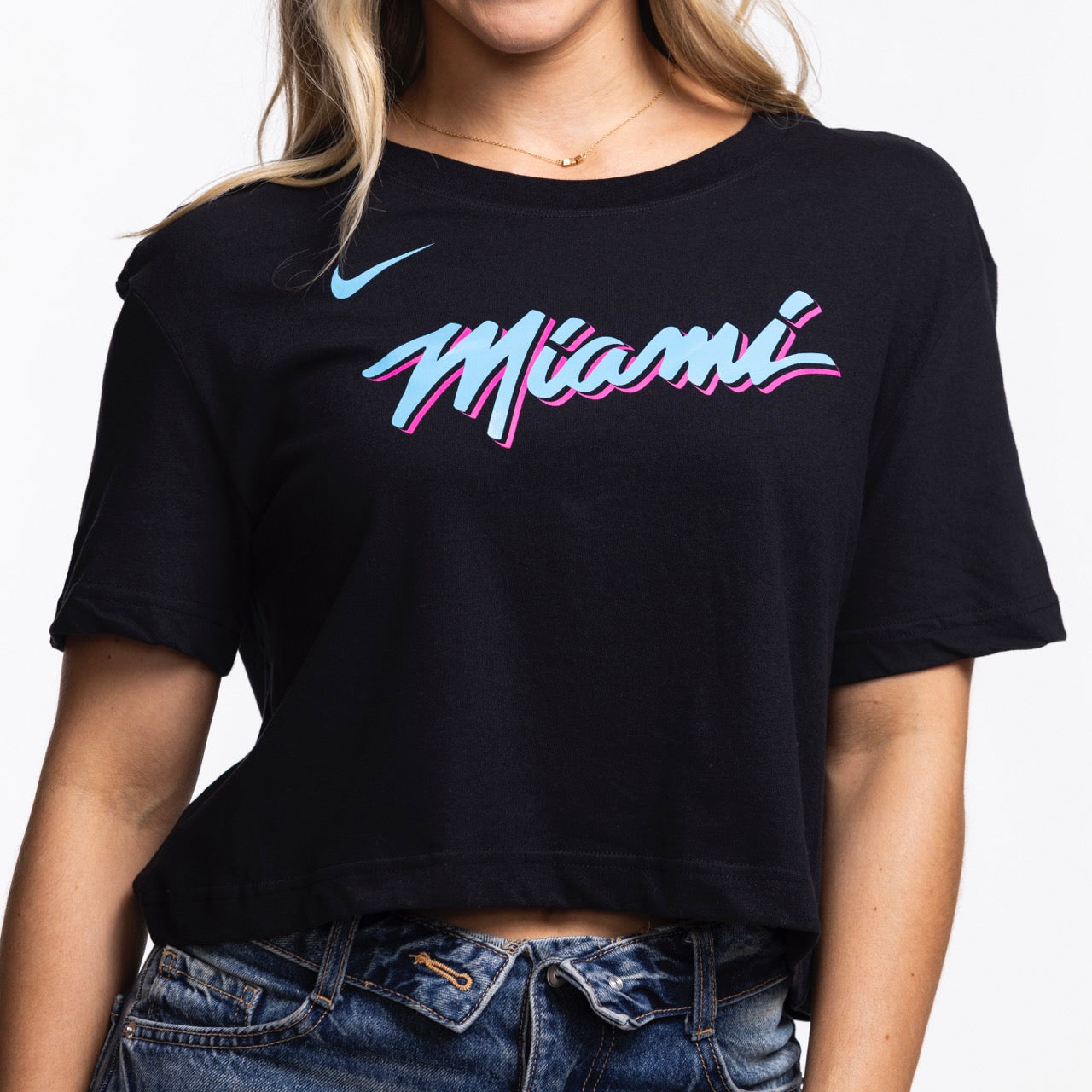 She wears the Nike Miami HEAT Original Vice Nights Cropped Women's Tee, featuring 