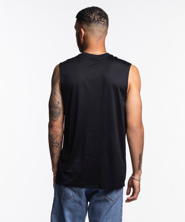 A man with short hair and a tattooed right arm wears a Nike Miami HEAT Original Vice Nights Sleeveless Tee in black and blue jeans. He looks to his left against a plain white background. Wash with like colors.