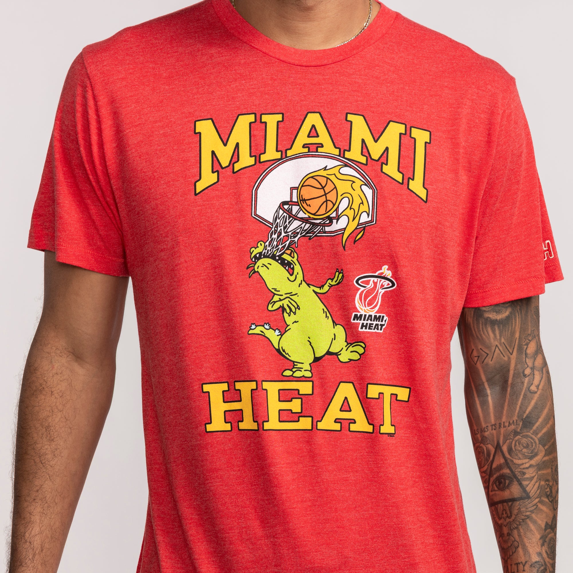 Red short-sleeve tee featuring Miami HEAT text and Reptar cartoon dunking a basketball. - Homage Miami HEAT Reptar Red Tee