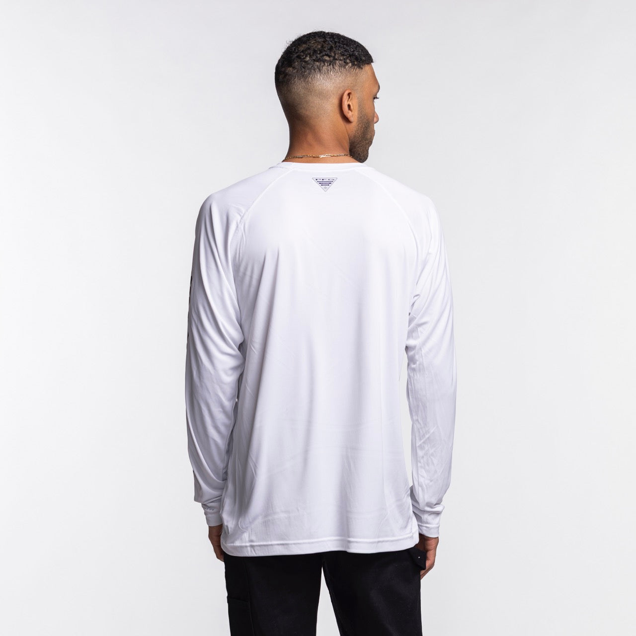 A man with short hair stands with his back to the camera against a plain white background, wearing the Columbia Miami HEAT Logo Terminal Long Sleeve Tee by Columbia Outdoor.