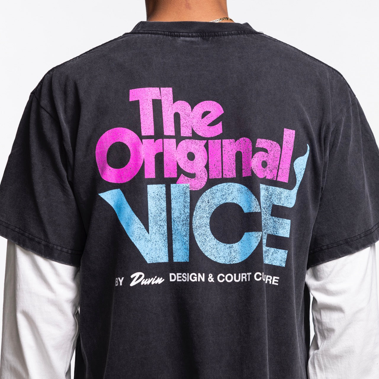 Wearing the black Court Culture x Duvin Original Vice Long Sleeve Tee, featuring bold pink and blue 