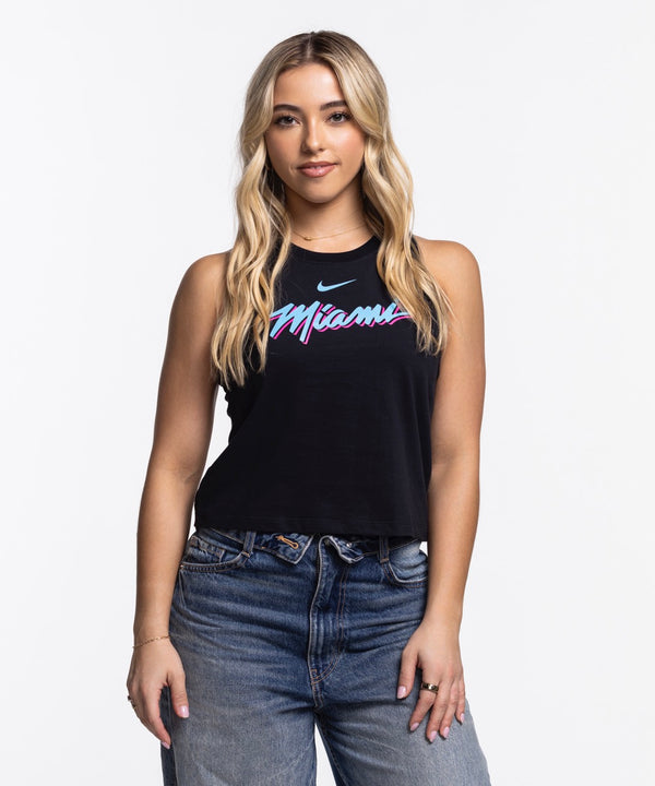 A woman with long blonde hair wears the Nike Miami HEAT Original Vice Nights Cropped Women's Tank—a black sleeveless top featuring colorful 