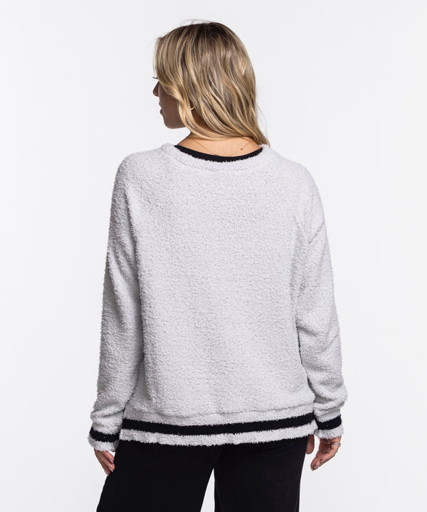 A woman with long, blonde hair wears the Concepts Sports Miami HEAT Original Vice Nights Women's Crewneck—an oversized, 100% cotton light gray sweatshirt with 