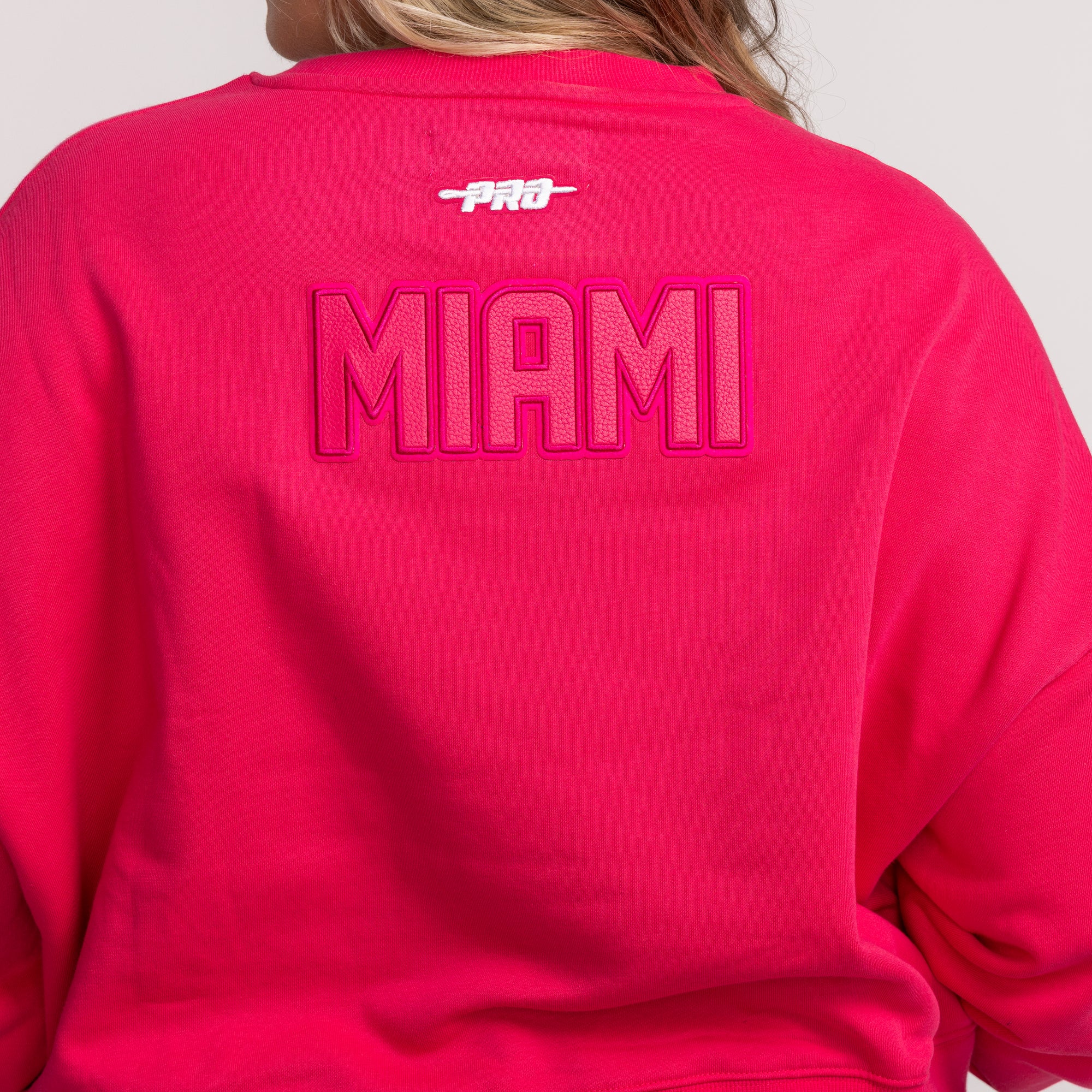 Pink crewneck sweatshirt with Miami HEAT logo embroidered on the back and Pro Standard branding above. - Pro Standard Miami HEAT Original Vice Pink Women's Crewneck