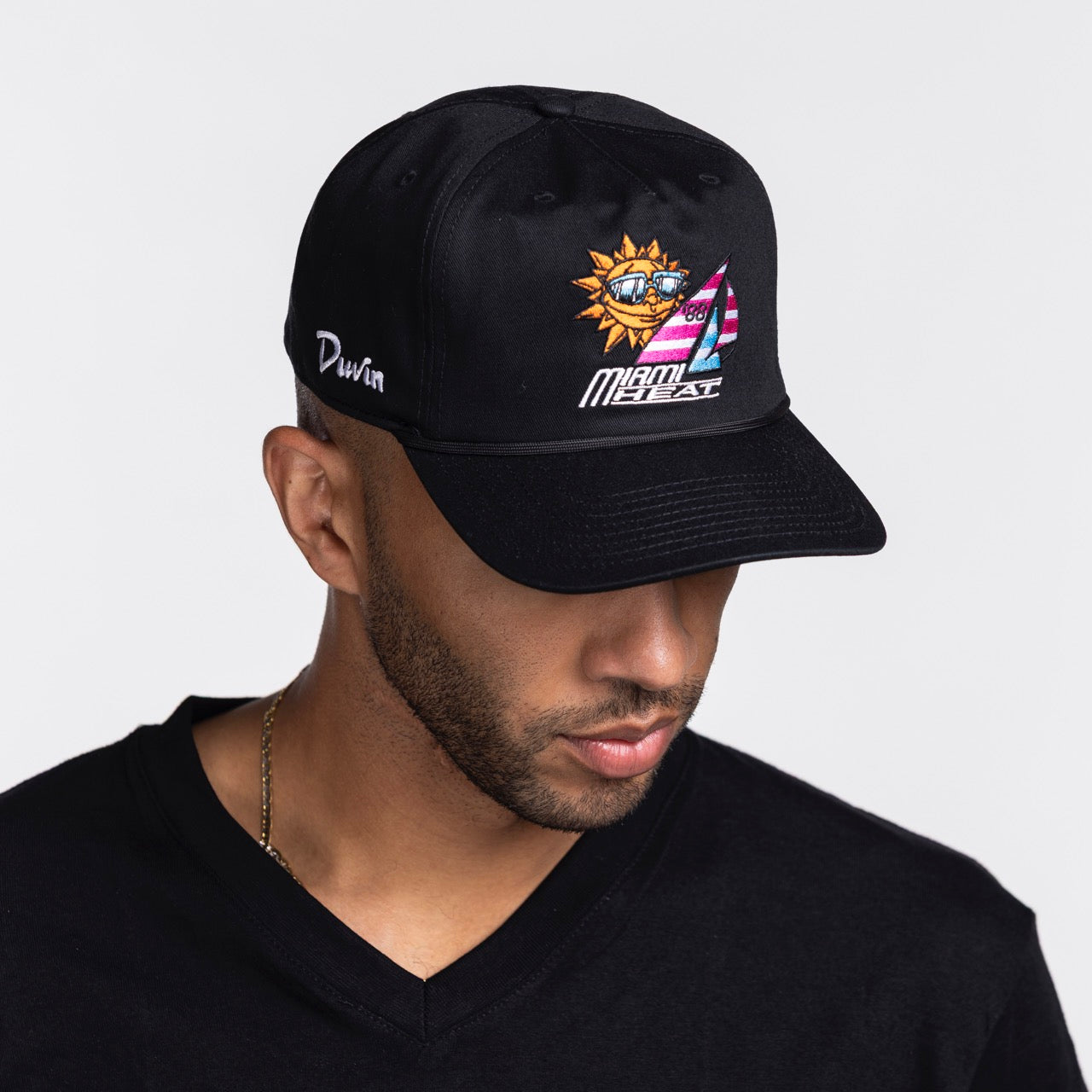 A man in a black V-neck shirt and the Court Culture Miami HEAT x Duvin Original Vice Nights 