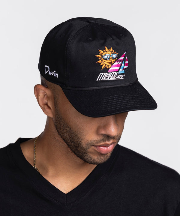 A man in a black V-neck shirt and a Court Culture Miami HEAT x Duvin Original Vice Nights 