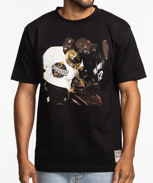 A man in light blue jeans and a Court Culture x Mitchell & Ness 