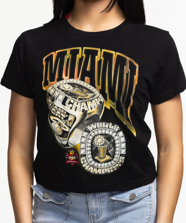 A woman with straight dark hair, smiling against a plain white background, wears a relaxed fit black Court Culture 