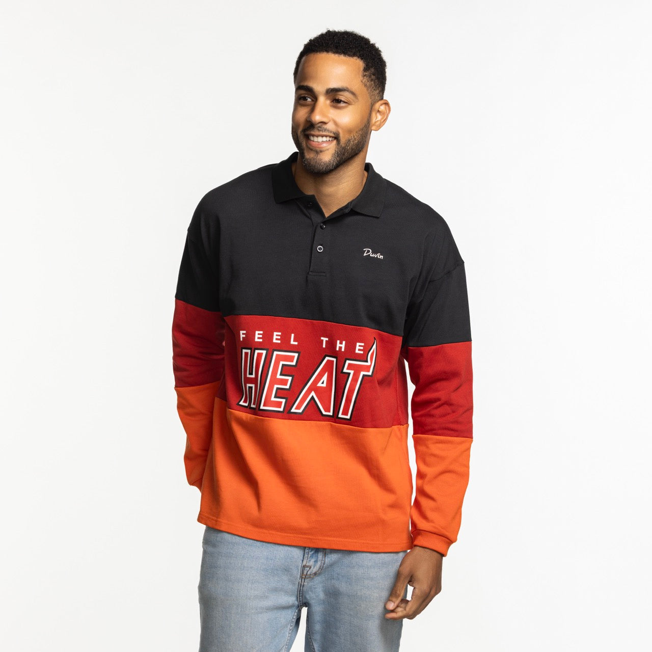 A man smiles in a relaxed fit Court Culture x Duvin Rugby Polo by Court Culture, featuring black, red, and orange pre-shrunk pique cotton with 