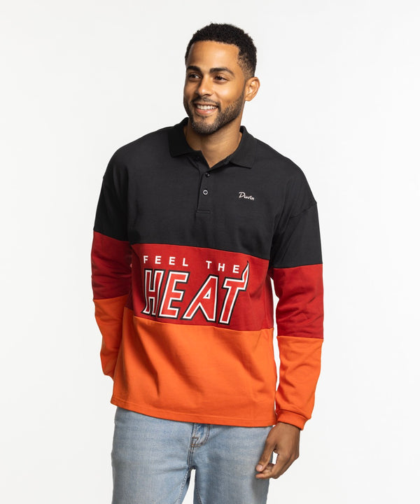 A man smiles in a relaxed fit Court Culture x Duvin Rugby Polo by Court Culture, featuring black, red, and orange pre-shrunk pique cotton with 