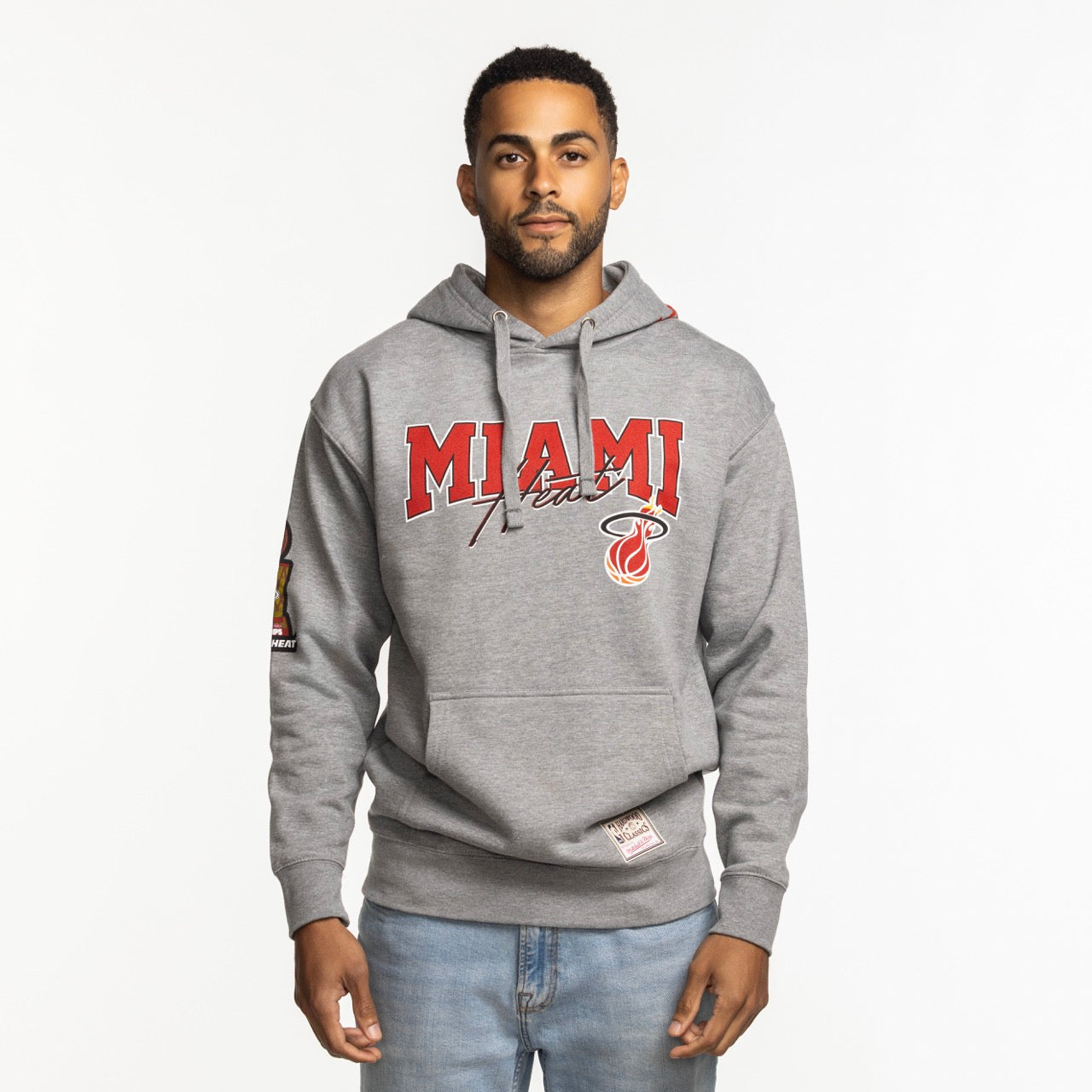 A man faces forward wearing the Mitchell & Ness Miami HEAT 2013 Champions Hoodie, featuring 