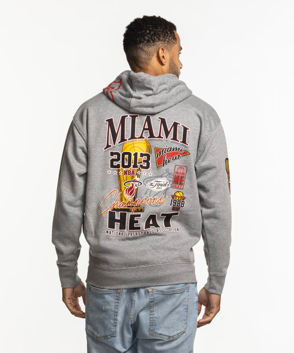 A man faces forward wearing the Mitchell & Ness Miami HEAT 2013 Champions Hoodie, featuring 