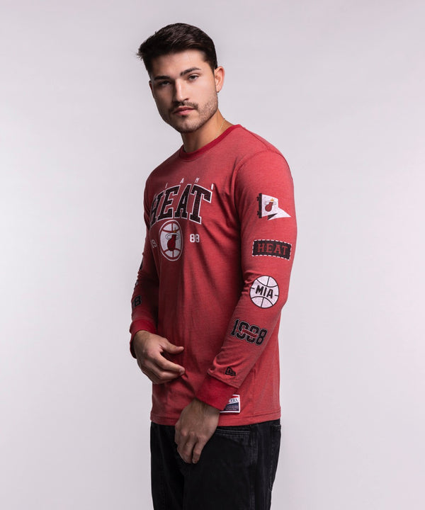 A man stands facing forward wearing the New Era Miami HEAT Red Cuffed Long Sleeve Tee, featuring a HEAT basketball logo and 