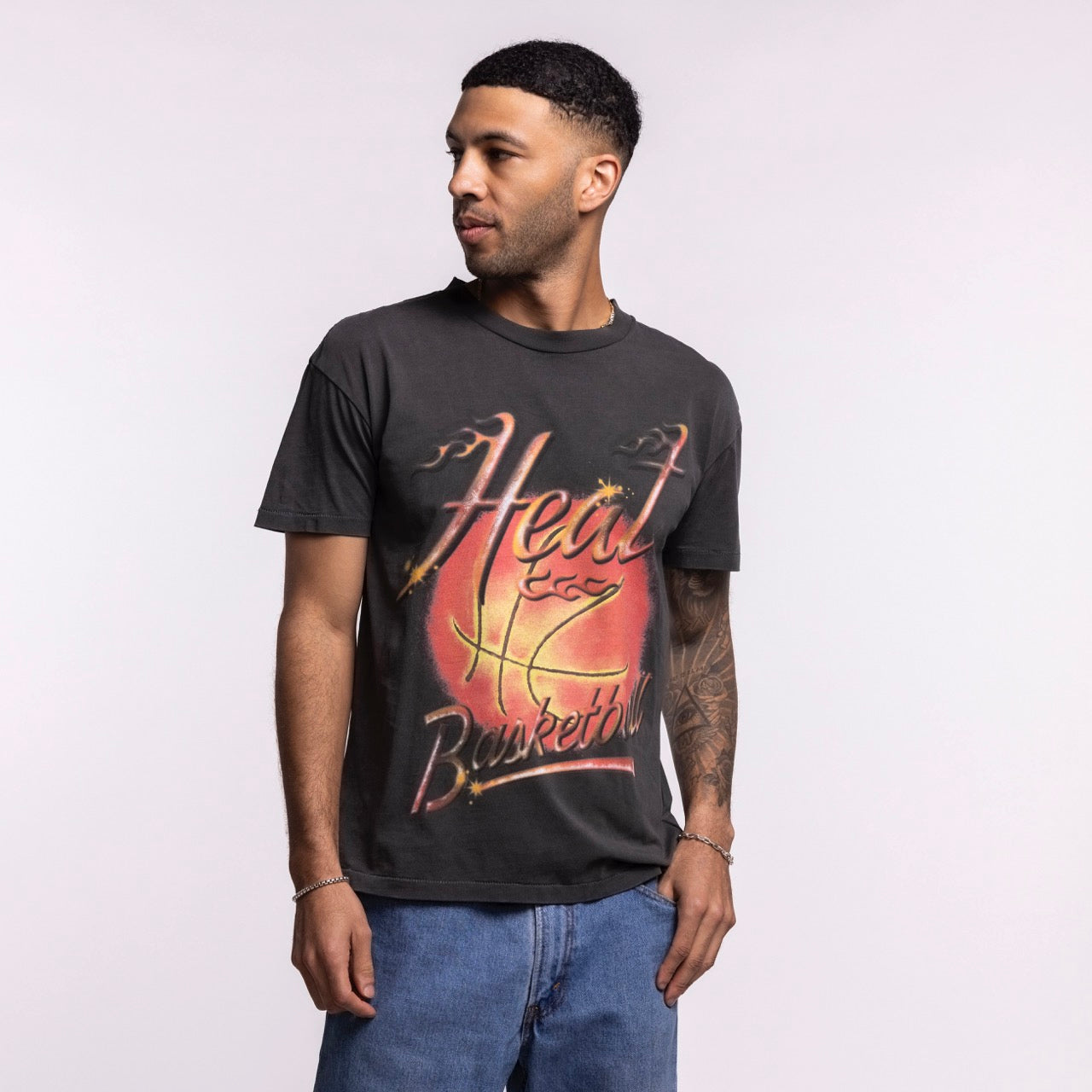 A man stands against a light background wearing the Court Culture 