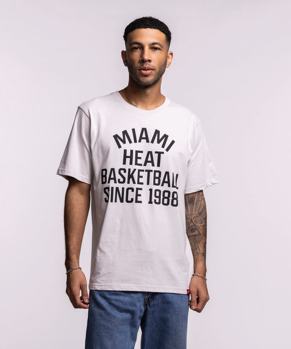 A man wearing the Sportiqe Miami HEAT 1988 Basketball Tee—white, standard fit, 100% cotton with 