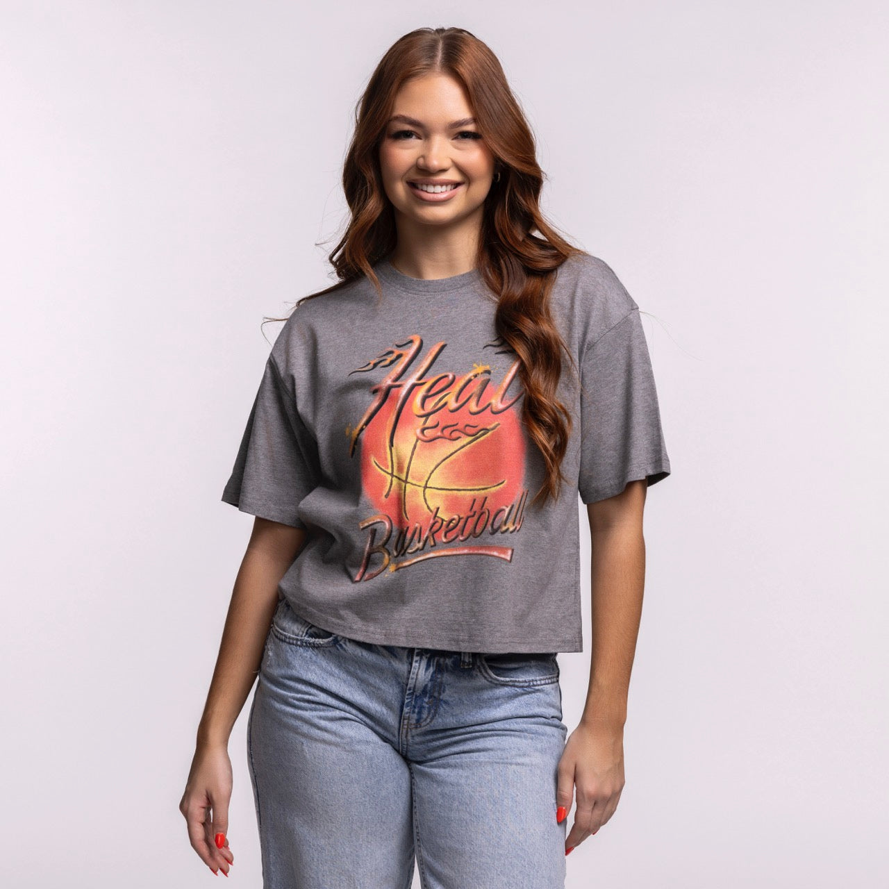 A young woman with long reddish-brown hair smiles in the Court Culture 