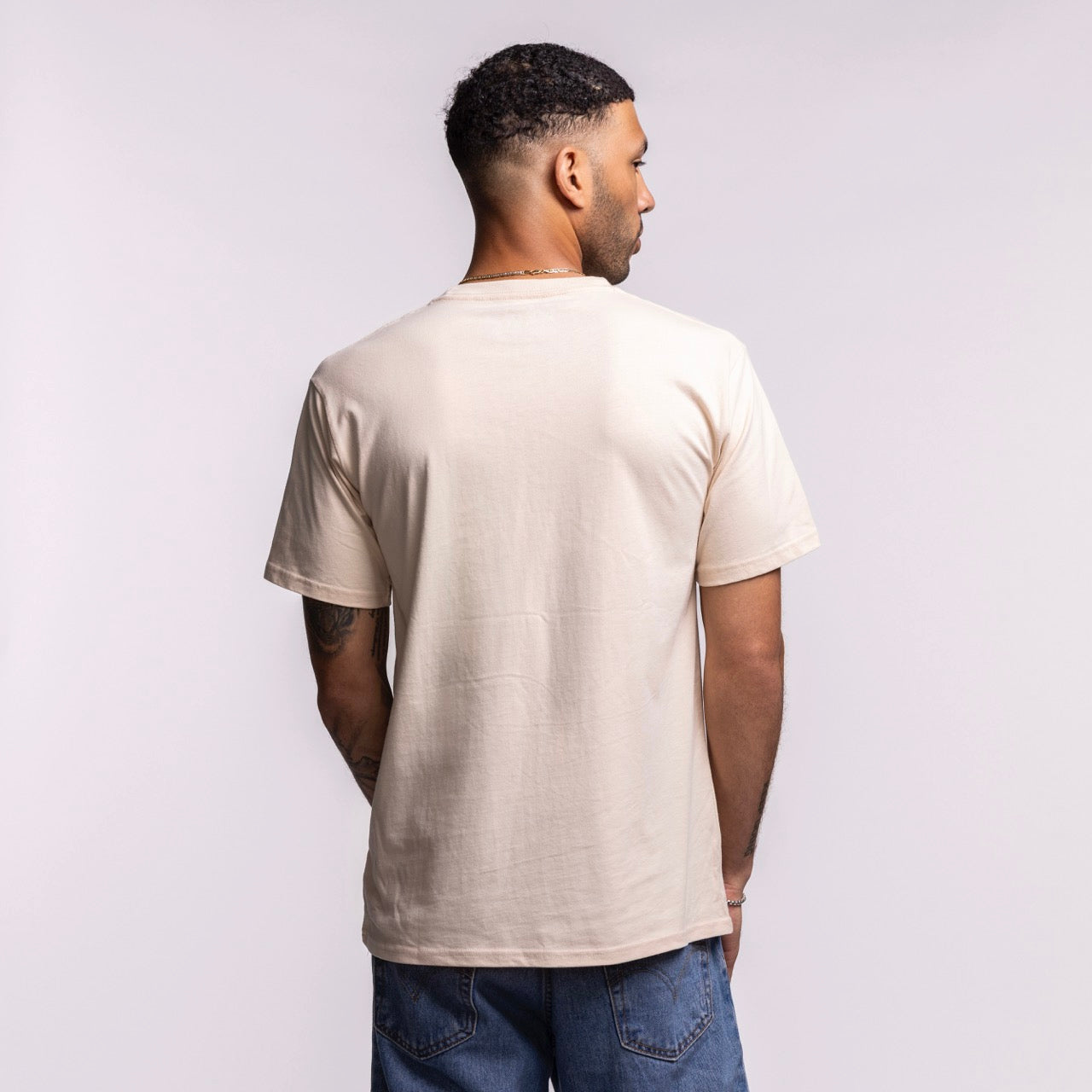 A man with short, dark hair faces away from the camera, wearing the Court Culture 