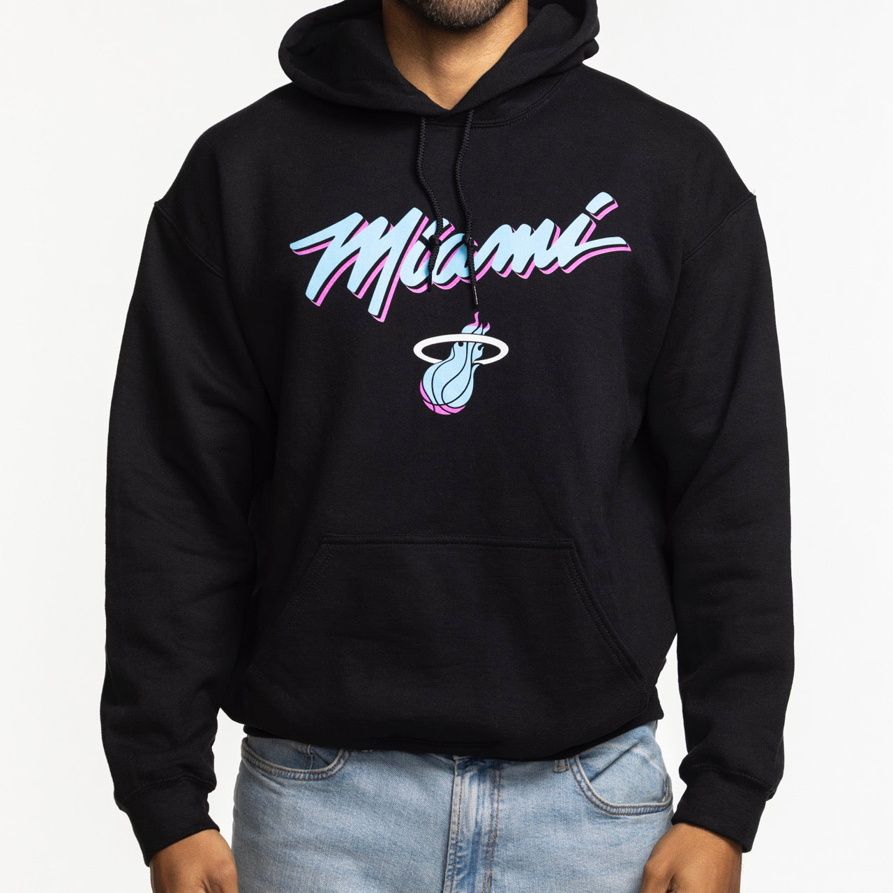A person wears the Miami HEAT Original Vice Nights Logo Hoodie by Item Of The Game—a black, standard fit cotton-poly blend with 