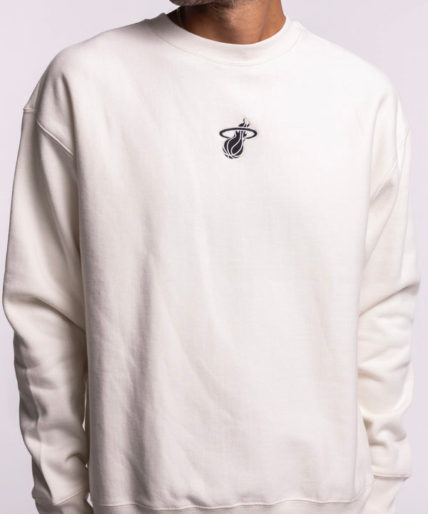 A man smiles against a light background, wearing the '47 Brand Miami HEAT Cream Logo Foundation Crewneck with a soft brushed interior and small embroidered logo on the chest, paired with blue jeans.