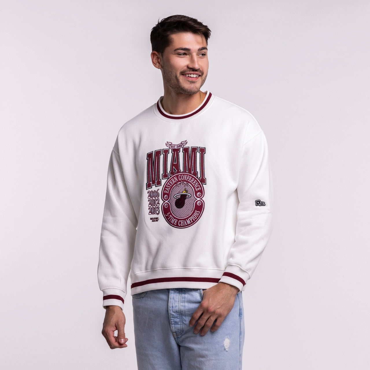 A man smiles against a plain light background wearing the Court Culture 