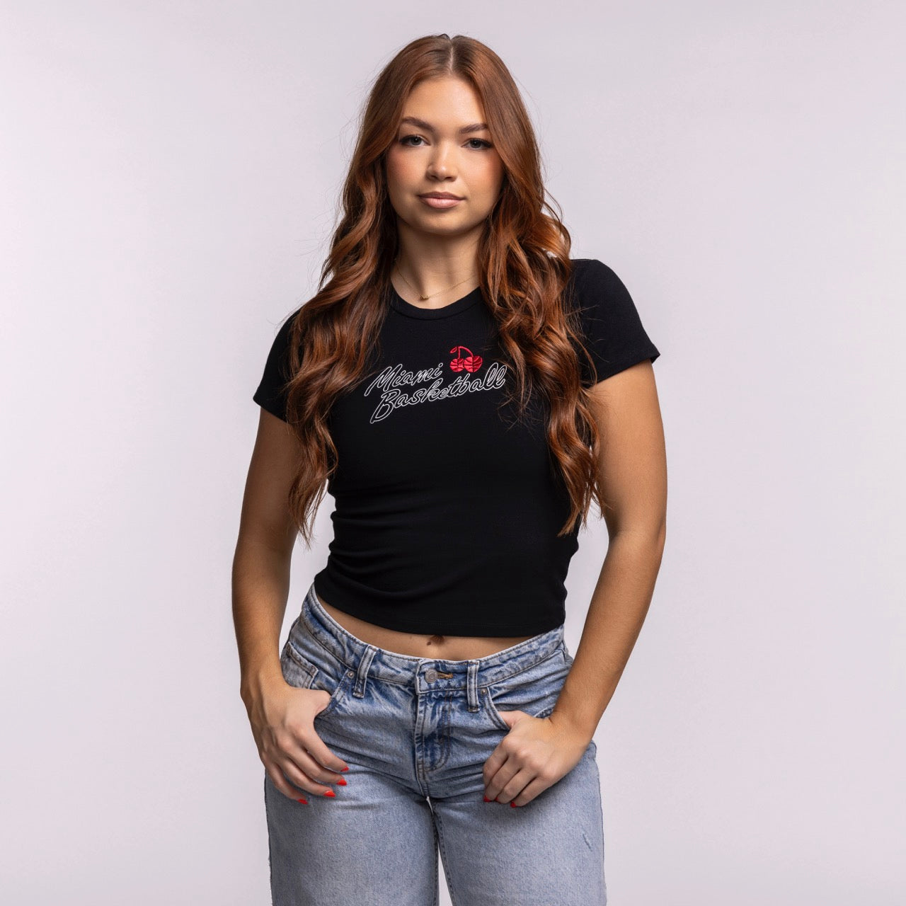 A young woman with long, wavy brown hair models the Court Culture 