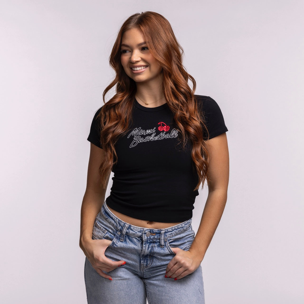 A young woman with long, wavy red hair wears a Court Culture 