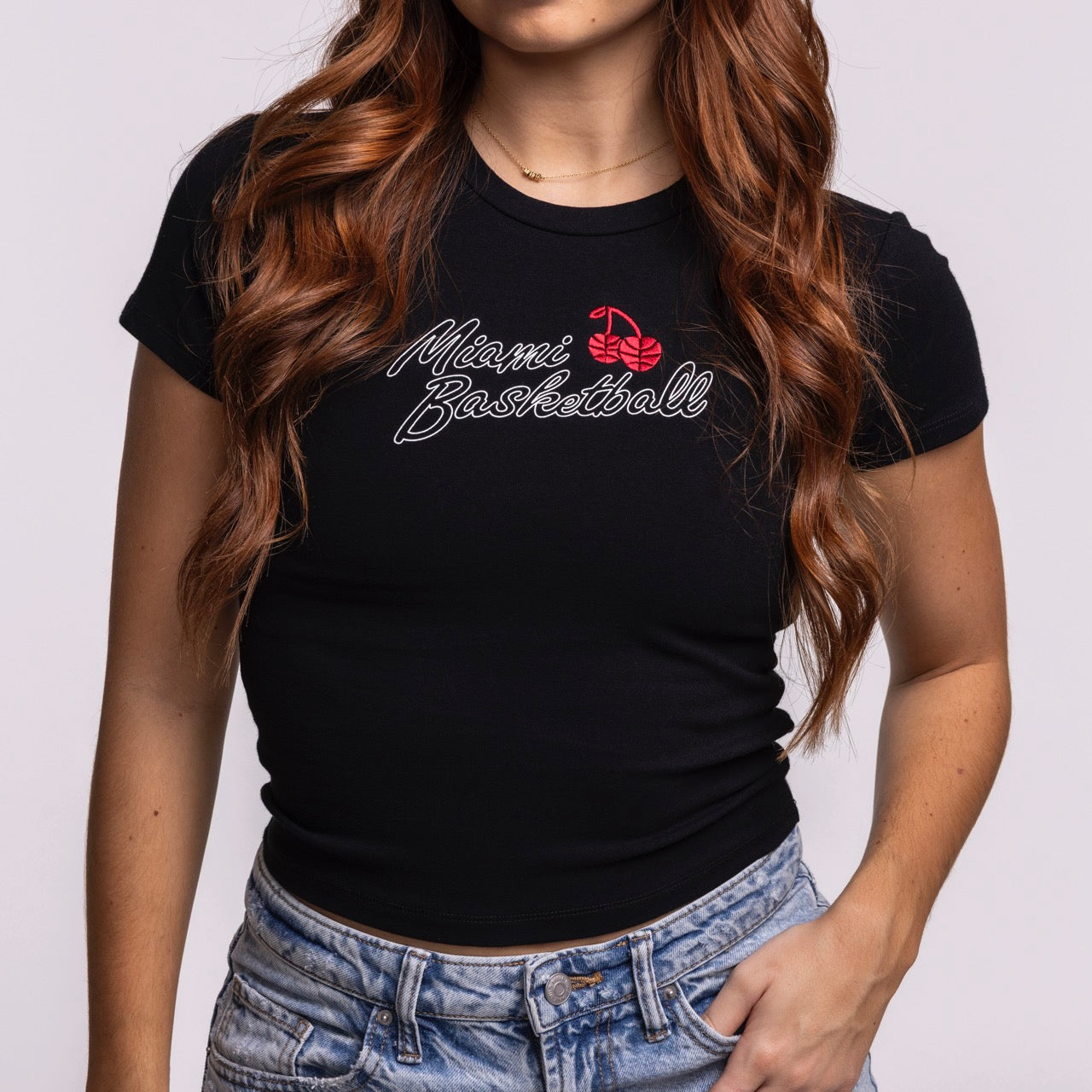 A woman with long wavy auburn hair wears the Court Culture 