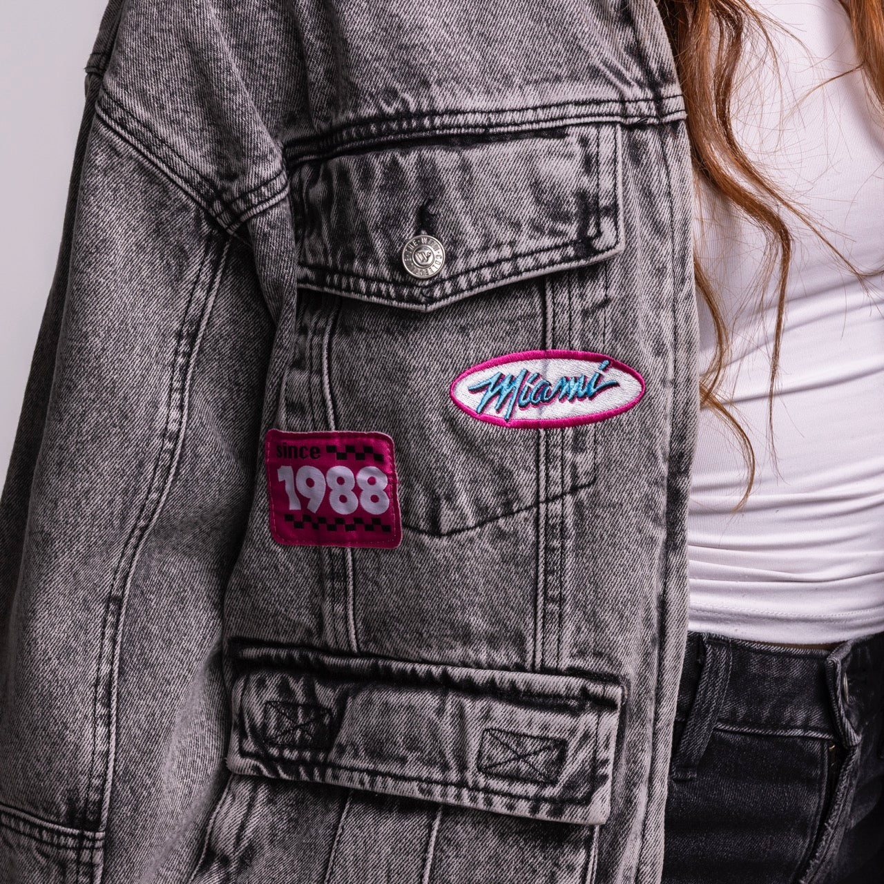 Close-up of a person wearing the Court Culture X The Wild Collective Original Vice Nights Denim Patch Unisex Jacket with 