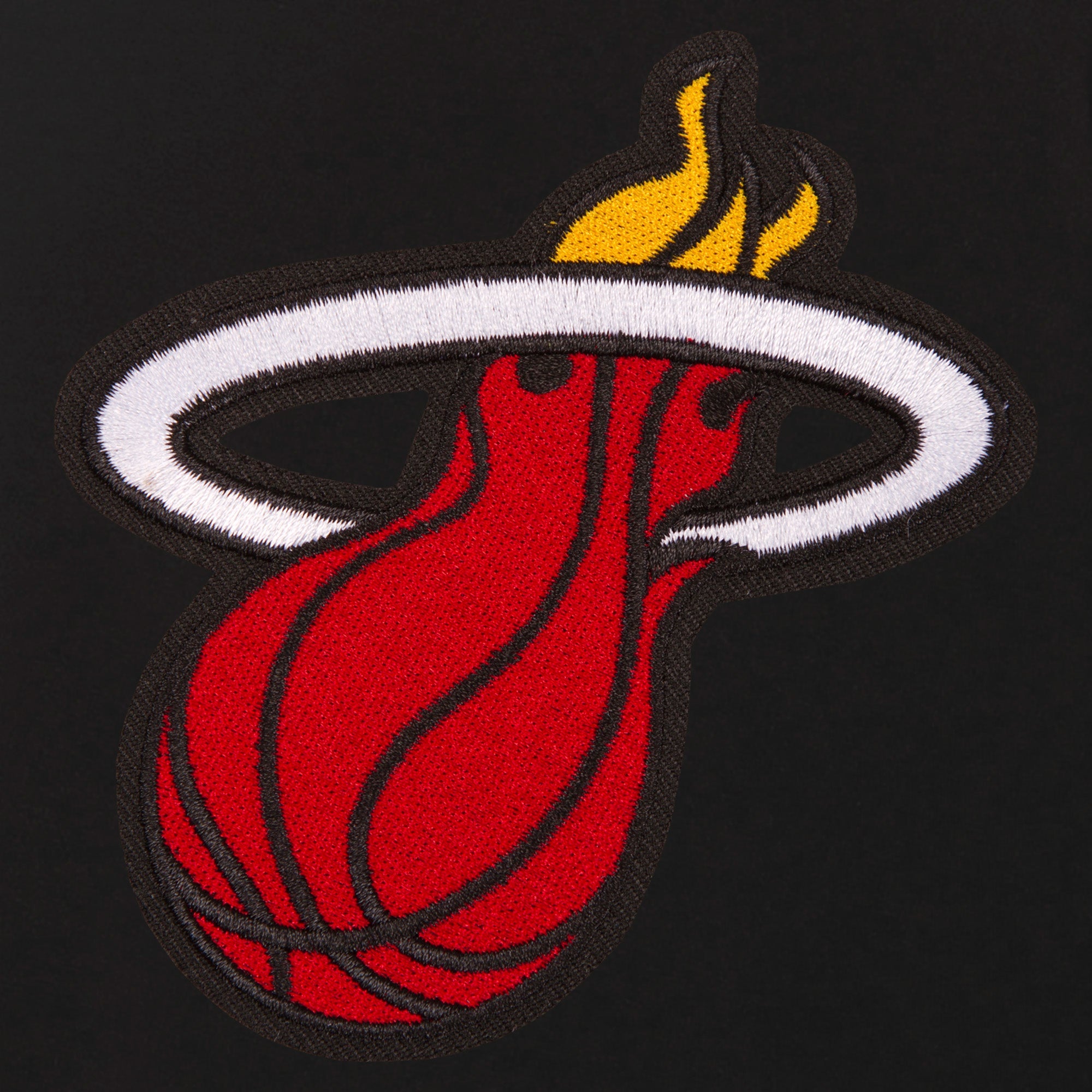 The image shows the embroidered Miami Heat logo—a red basketball with flames through a white hoop—on a black JH Designs Miami HEAT Ladies Reversible Fleece Jacket, featuring a metal zip closure.