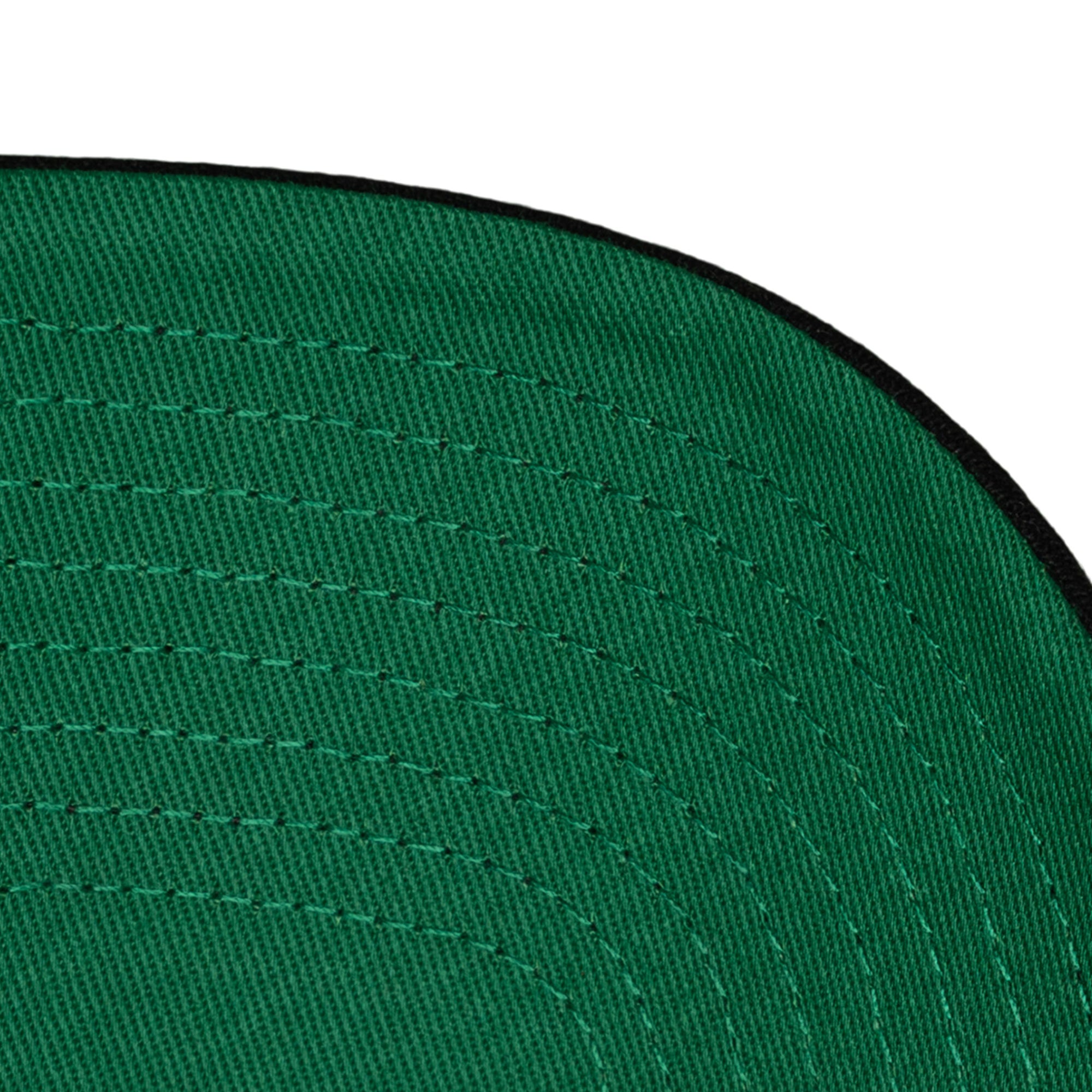 Close-up of the underside of the Mitchell & Ness Miami HEAT Back-To-Back Champs Snapback's green polyester brim with curved stitching and a black edge; spot clean recommended.