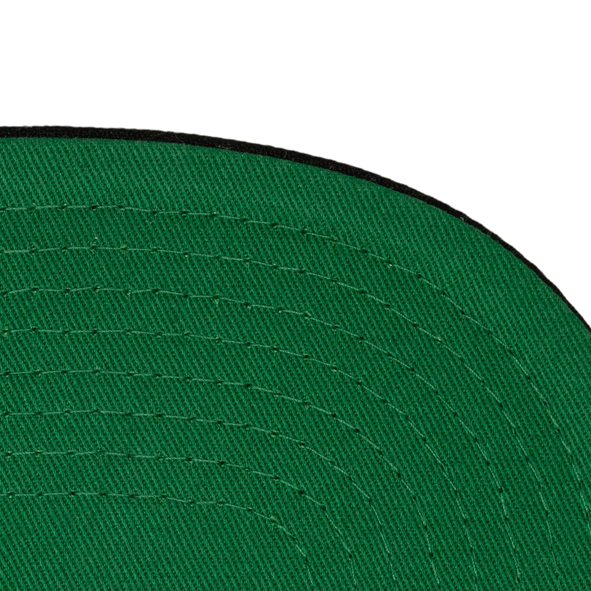 Close-up of the underside of a green polyester brim with visible stitching and a thin black edge on the Mitchell & Ness Miami HEAT '96 All-Star Snapback; one size fits most.