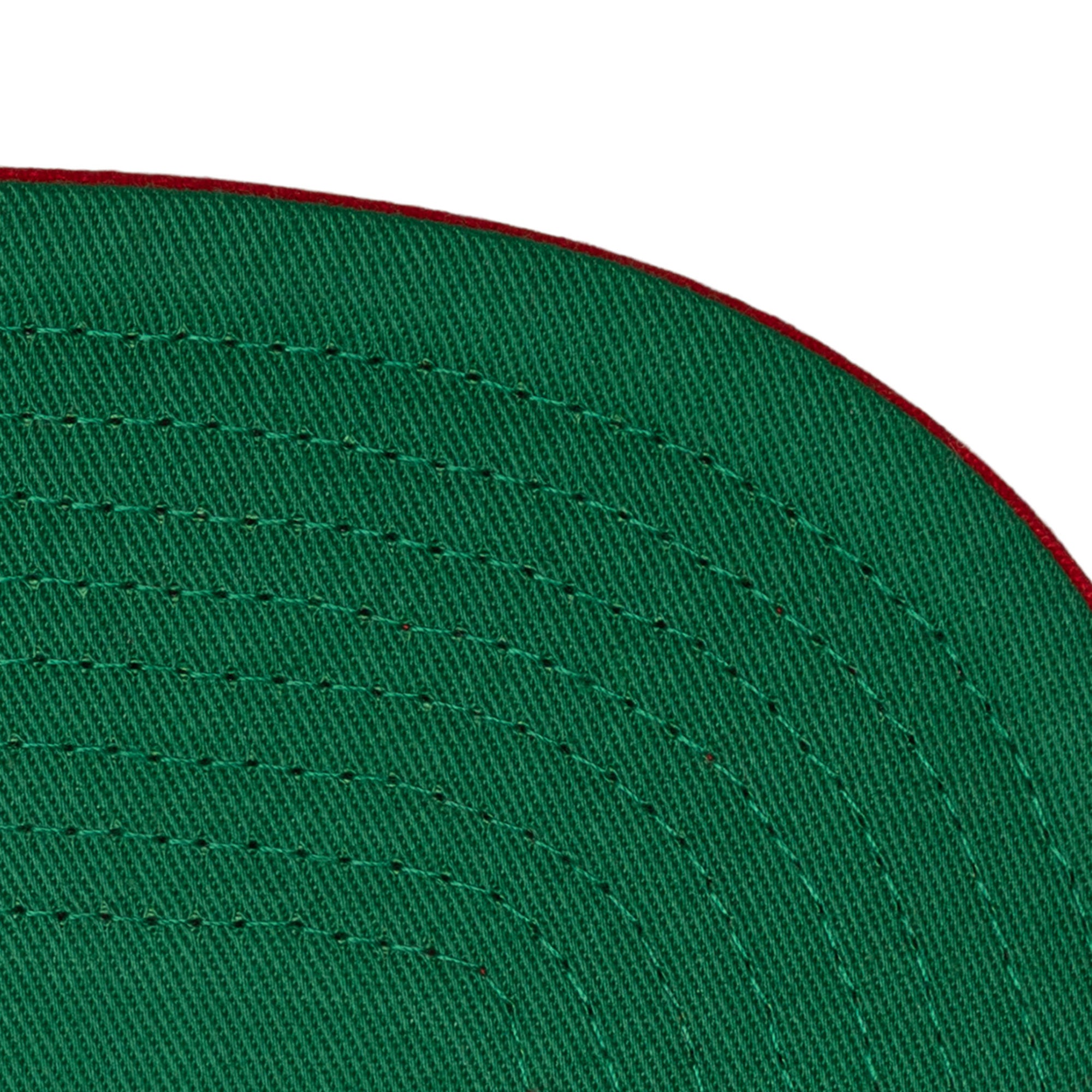 Close-up of the underside of the Mitchell & Ness Miami HEAT Pinstripe Snapback brim, featuring green polyester, detailed stitching, and a thin red edge. One size fits most. Spot clean for best care by Mitchell & Ness.
