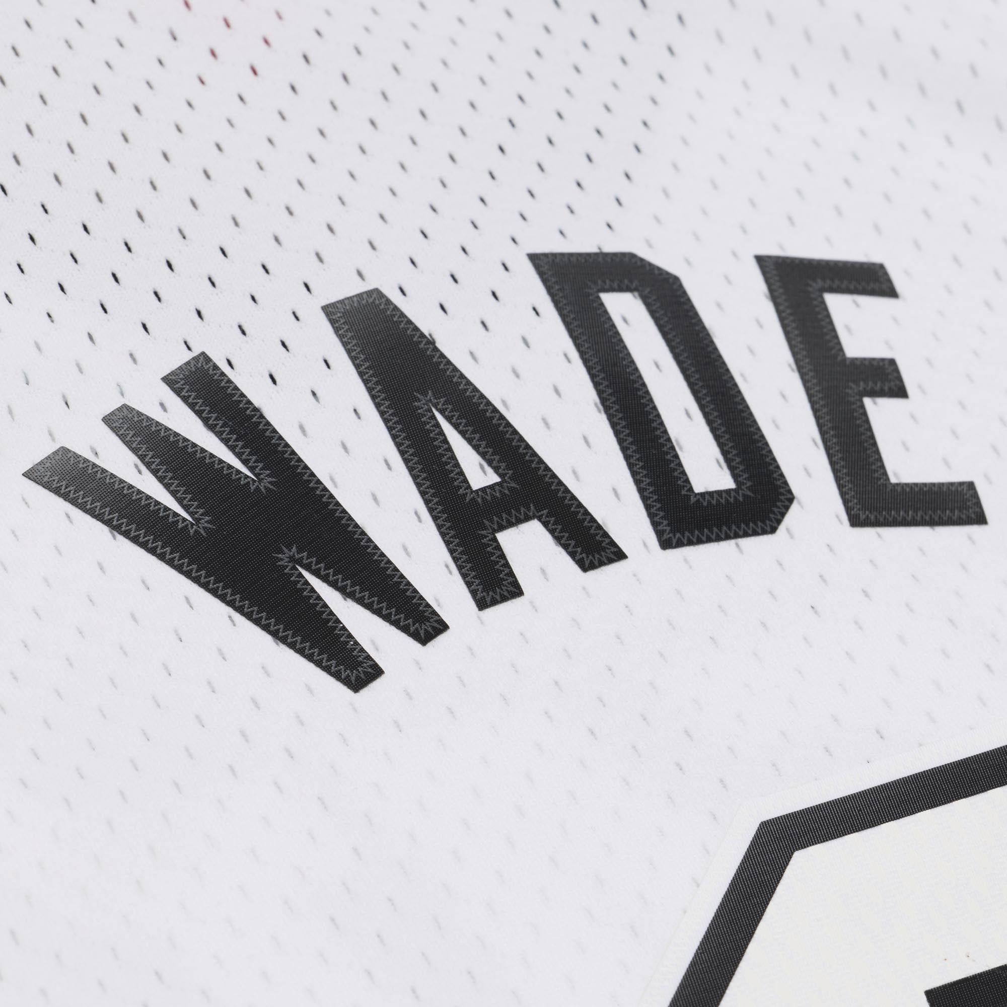 A Dwyane Wade Mitchell & Ness Miami HEAT White Hot 2012-13 Swingman Jersey made of white polyester with WADE printed in black twill letters across the back.