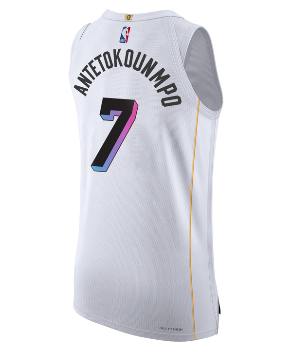 Giannis Antetokounmpo Nike Miami Mashup Vol. 2 Authentic Jersey by Nike features a white design with colorful Miami text, number 7, sponsor logos, and yellow side accents. Bold twill team and player details stand out along with a classic striped knit armhole for added style. The words “15 STRONG” appear above the NBA jock tag near the bottom hem.