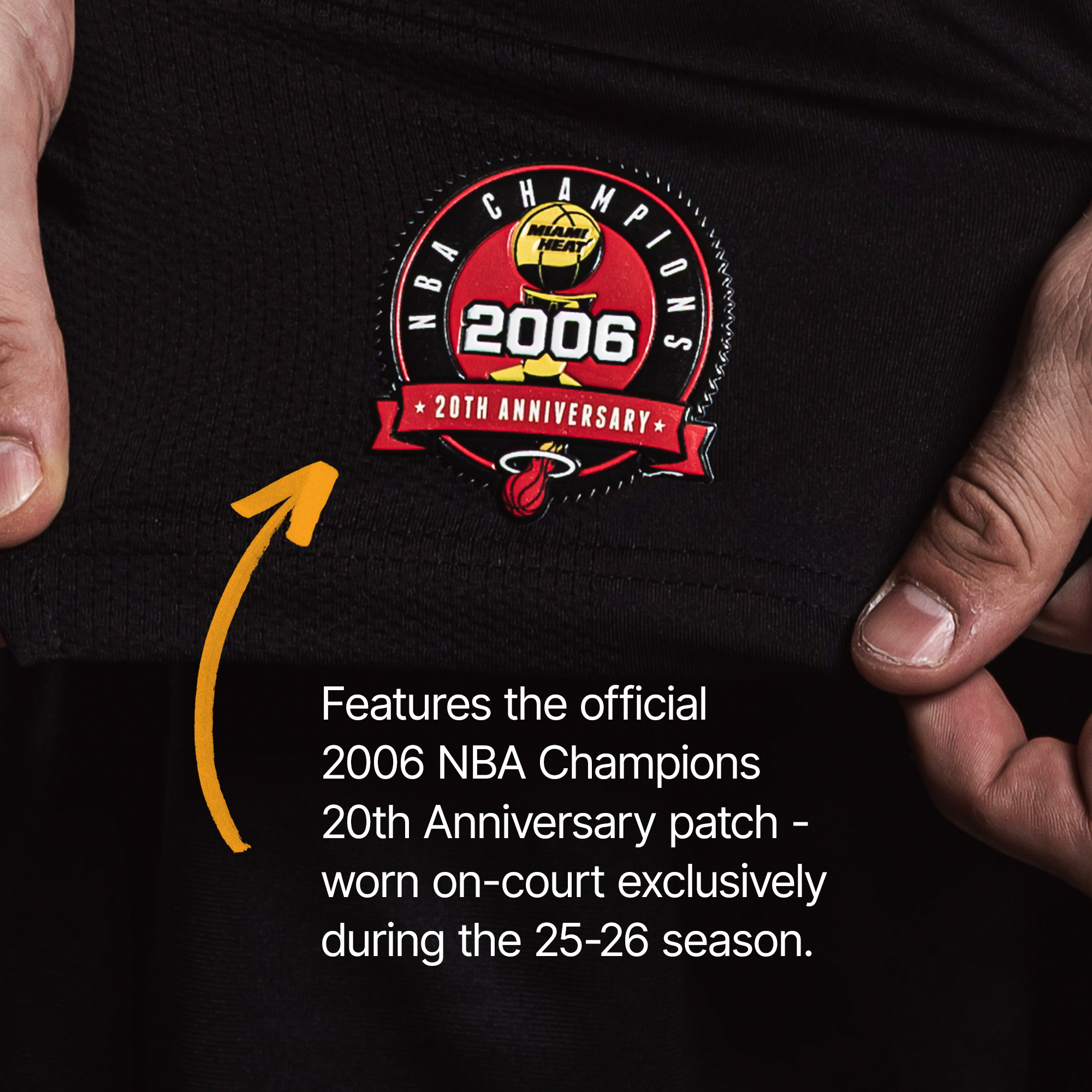 Close-up of a hand holding the Nike Tyler Herro Miami HEAT Icon Black Swingman Jersey, featuring a commemorative 