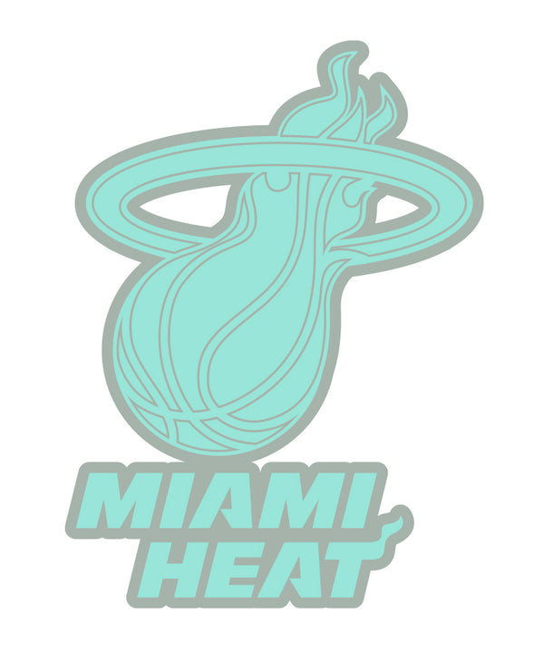 The Pro Specialties Miami HEAT Glow In The Dark Pin features the team's pastel teal logo with a flaming basketball and bold lettering below, adding a unique glow for collectors and fans.