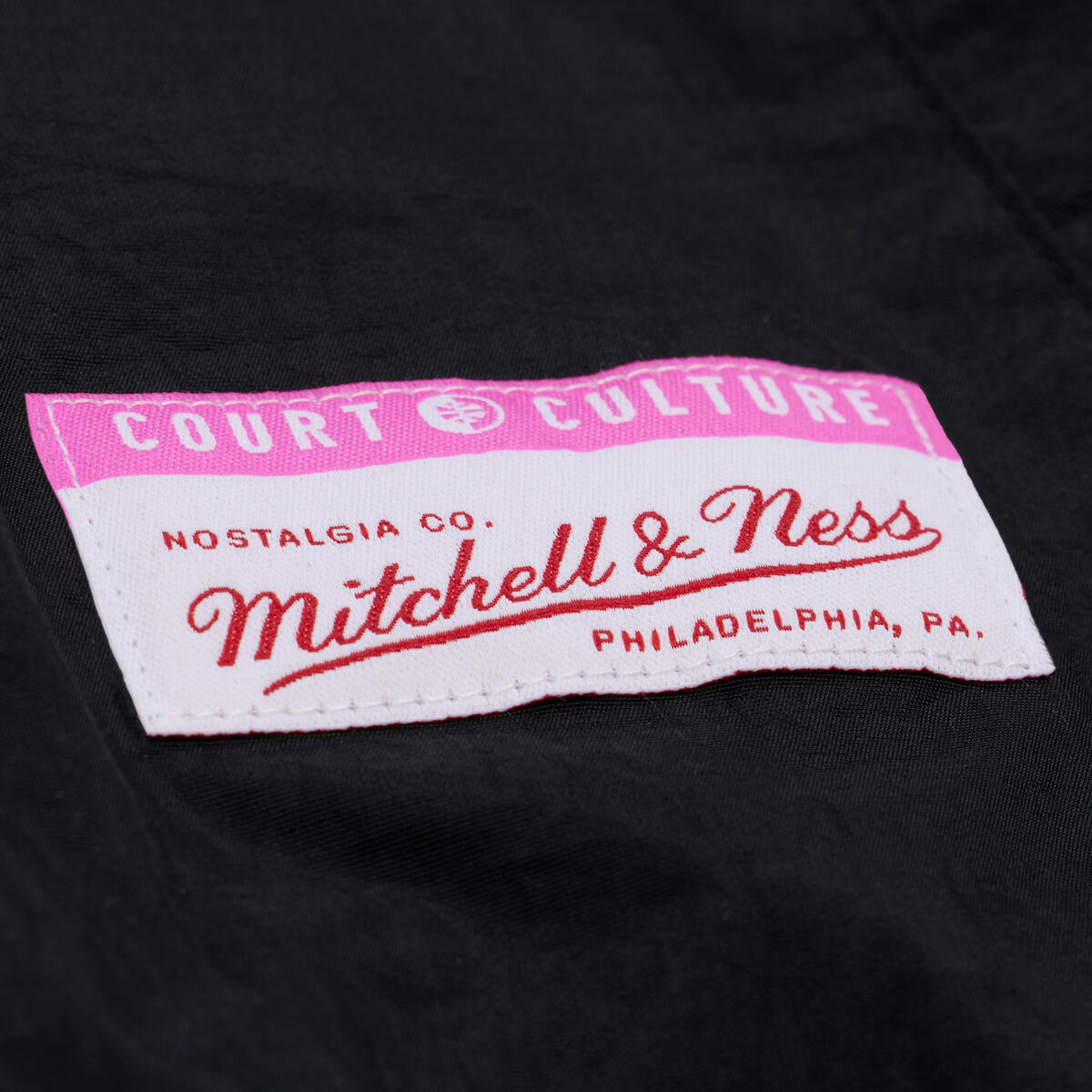 A close-up of the fabric label on the Court Culture x Mitchell & Ness Original Vice Nights 